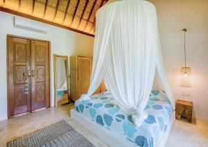 a bedroom with a bed with a canopy at Mule Malu Tropical Stay in Uluwatu