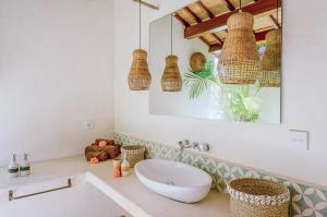 a bathroom with a white sink and a mirror at Mule Malu Tropical Stay in Uluwatu
