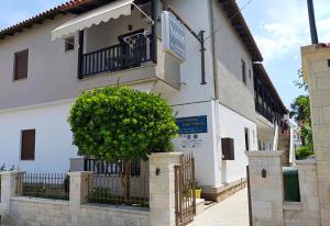 a white building with a tree in front of it at Yannis Apartments in Afitos