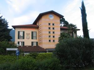 a large building with a clock on the front of it at Hotel Antica Stallera in Cannobio