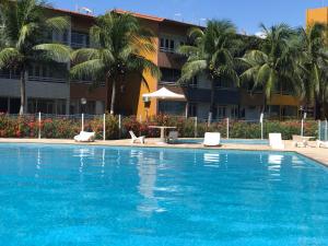 una piscina frente a un hotel con palmeras en Apartamentos Praia do Futuro Prox Chico do Caranguejo, en Fortaleza