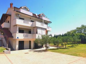 duży biały budynek z drzewami przed nim w obiekcie Apartments Ana Medulin w Medulinie
