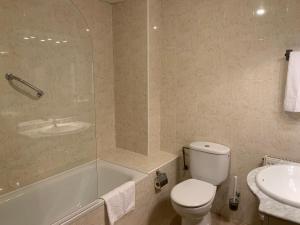 a bathroom with a toilet and a tub and a sink at Aparthotel /Apartamentos Turísticos Raquel's in Sant Pere Pescador