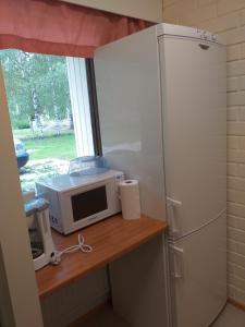 a kitchen with a microwave and a refrigerator at Huoneistohotelli Teekki in Muuruvesi