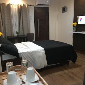 1 dormitorio con cama y mesa con vajilla en MIRASOL Residences, en Daet