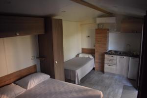 a small room with two beds and a kitchen at OasiHome in SantʼAndrea