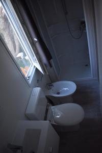 a small bathroom with a toilet and a sink at OasiHome in SantʼAndrea