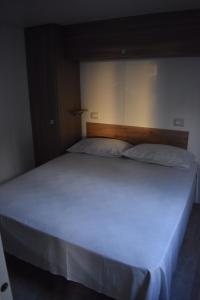 a bedroom with a large white bed in a room at OasiHome in SantʼAndrea
