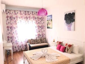 KallirákhiにあるEvmorfias Houseのベッドルーム1室(ピンクの弓が付いたベッド1台付)