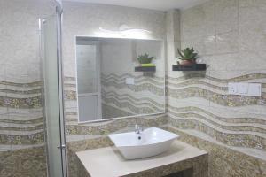 een badkamer met een wastafel en een spiegel bij Sawanga Home Stay in Weligama