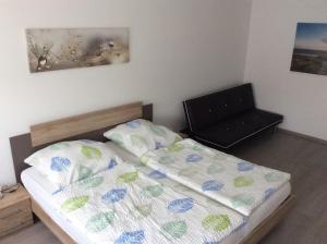 ein kleines Schlafzimmer mit einem Bett und einem Stuhl in der Unterkunft Apartment Perla in Limburg an der Lahn
