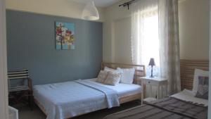 a bedroom with two beds and a window at Ege Han Hotel in Bozcaada
