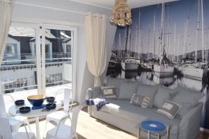 a living room with a couch and a table and boats at Apartament Silence Baltic Róża Wiatrów in Pobierowo