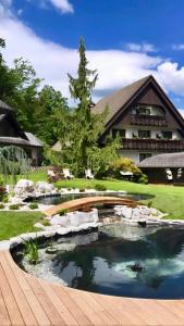 un jardín con un estanque frente a una casa en Alp Pension en Bled