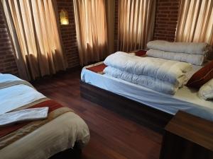 Giường trong phòng chung tại HOTEL LAYAKU DURBAR