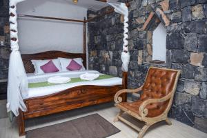 a bedroom with a wooden bed and a chair at Sama Jabal Shams Resort in Dār Sawdāʼ +28 photos