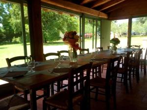 una mesa larga con sillas y jarrones con flores. en Agriturismo Contea di val d'amone, en Brisighella