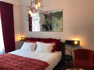 a bedroom with a bed with a red blanket and a mirror at Les Floralies Capucines in Marseille