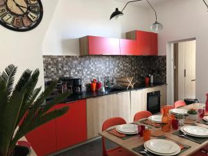 a kitchen with red cabinets and a table with chairs at Les Floralies Capucines in Marseille