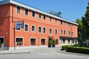 um grande edifício laranja com uma placa em frente em Hotel Almtalerhof em Linz