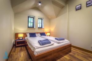 a bedroom with a bed with two blue pillows on it at A3 - APARTAMENTY in Mikołajki