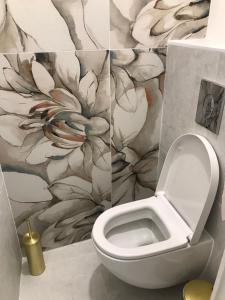 a bathroom with a toilet with a flower wallpaper at Les Floralies Capucines in Marseille +8 photos