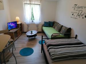 a living room with a couch and a table at Pension Hofmann in Volkholz