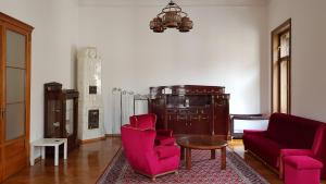 a living room with pink chairs and a table at Luxury apartment in the heart of Varazdin in Varaždin