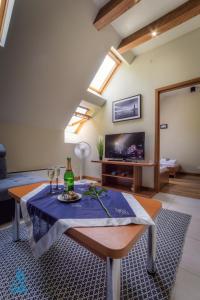 a living room with a table and a tv at A3 - APARTAMENTY in Mikołajki