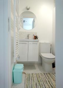 uma casa de banho com um WC, um lavatório e um espelho. em Cool Places em Limoges