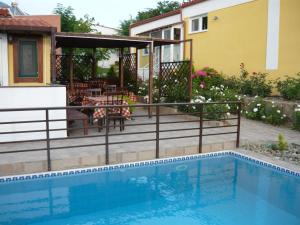 a swimming pool with a deck and a house at Victory Apartments Hotel in Samothraki +37 photos