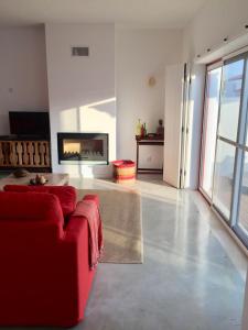 a living room with a red couch and a television at Casa Oliveiras in Comporta