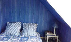 a blue bedroom with a bed and a side table at NEPTUNE in Lion-sur-Mer