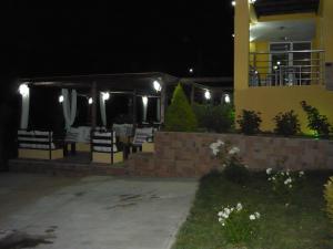 eine Terrasse mit Tischen und Stühlen in der Nacht in der Unterkunft Victory Apartments Hotel in Samothráki