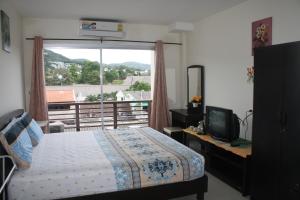a bedroom with a bed and a large window at We Love Kata in Kata Beach