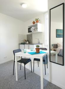 利摩日的住宿－Cool Places，白色的餐桌,配有两把椅子和镜子