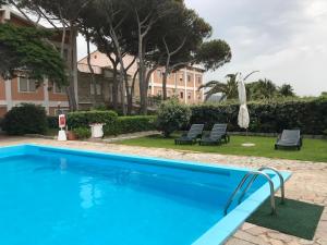 una piscina con due sedie e un edificio di La Casa di Gavino a Santa Teresa di Gallura