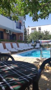 a pool with white lounge chairs next to a building at Complex Astra in Sunny Beach