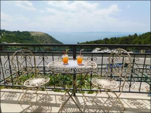 a table with two drinks on top of a balcony at House Monika in Krvavica