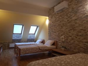 1 dormitorio con 2 camas y pared de ladrillo en Turistična kmetija Kaloh en Maribor
