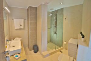 La salle de bains est pourvue d'une douche, de toilettes et d'un lavabo. dans l'établissement Aristea Apartments, à Paleóchora