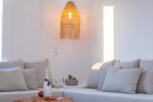 a white couch with a bottle of wine and glasses at Naxian Pearl in Mikri Vigla