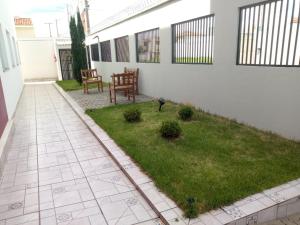 a patio with a lawn and two chairs in a yard at Hotel HOSPEDA Marília in Marília
