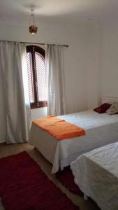 een slaapkamer met 2 bedden en een raam bij Villa Quiet Place in Luxor