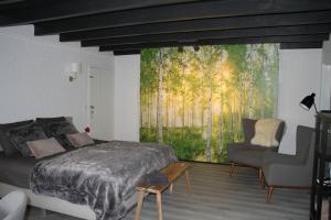a bedroom with a large window with a bed and a chair at B&B de Rekkendonken in Liempde