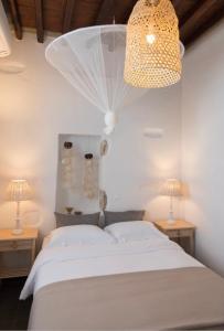 a bedroom with a bed with two lamps and a chandelier at Apollonion house in Apollonia