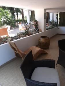 een woonkamer met een bank en stoelen en een patio bij Hotel Kiss in Cesenatico