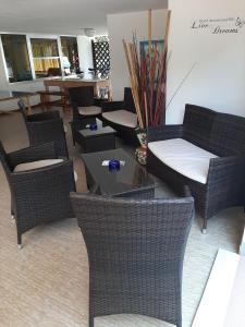 a lobby with wicker chairs and tables in a room at Hotel Kiss in Cesenatico