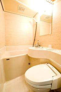 a bathroom with a toilet and a sink and a tub at Hotel Ohedo in Tokyo