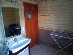 a bathroom with a sink and a wooden door at Sapphire Apartment in Rewal +37 photos